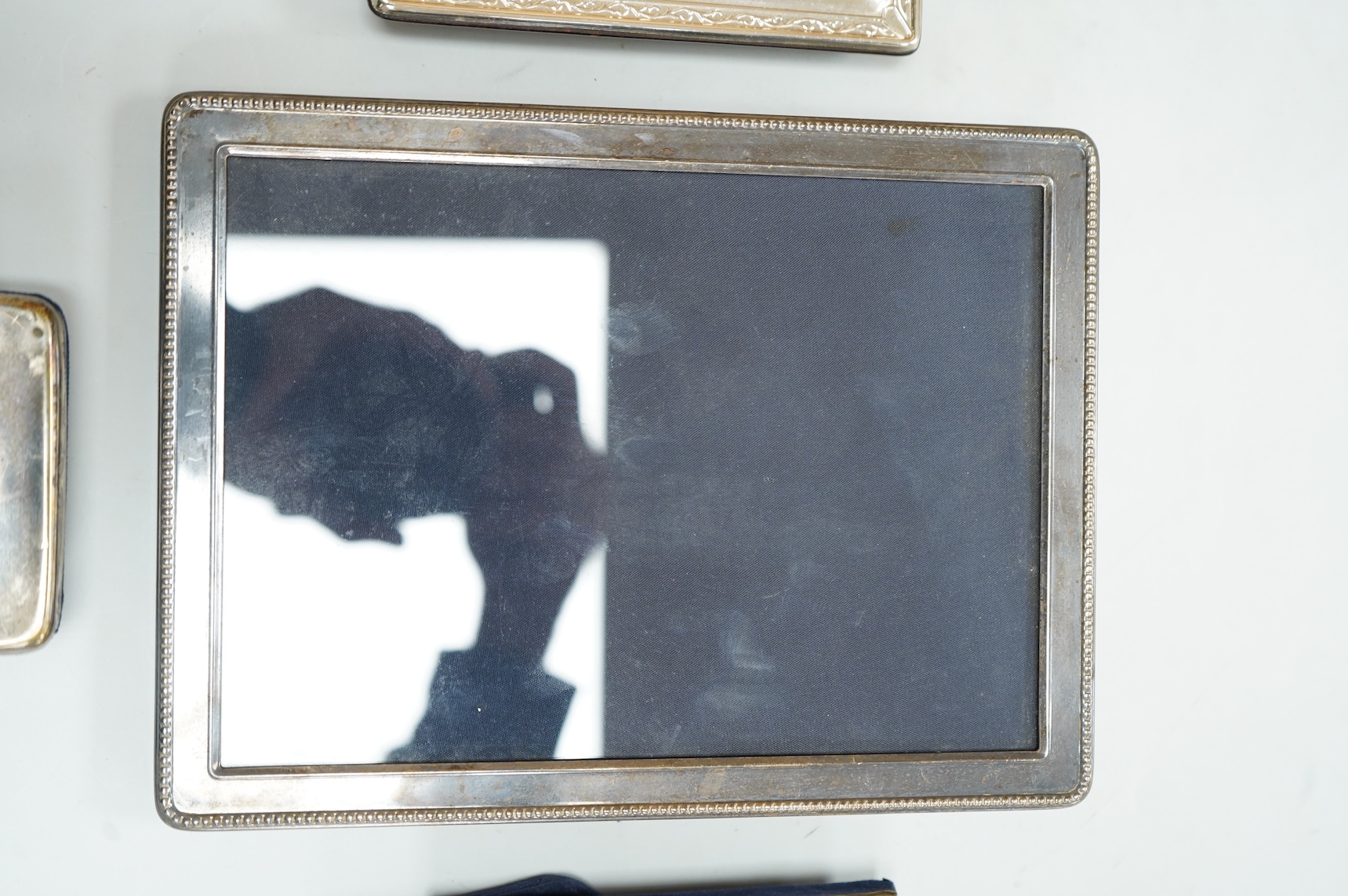 Two modern silver mounted photograph frames, largest 20.4cm by 15.2cm, an Italian 925 mounted photograph frame and a modern silver mounted desk timepiece.